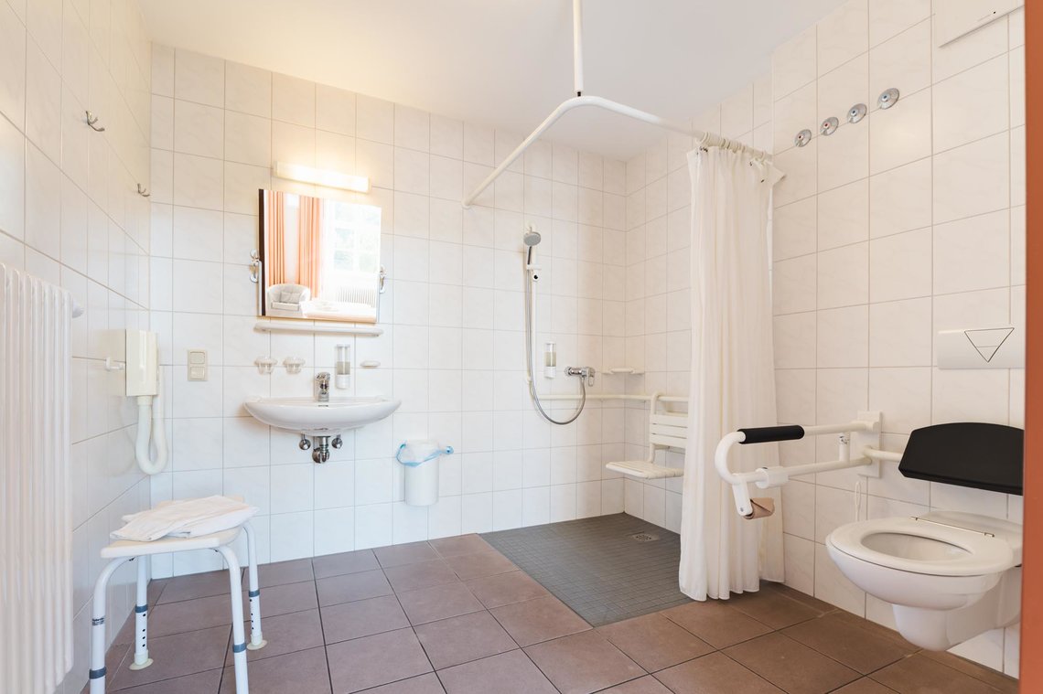 Ein großräumiges barrierefreies Bad, mit bodentiefer Dusche und barrierefreier Toilette